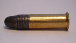 Pistol cartridge on purplish background.